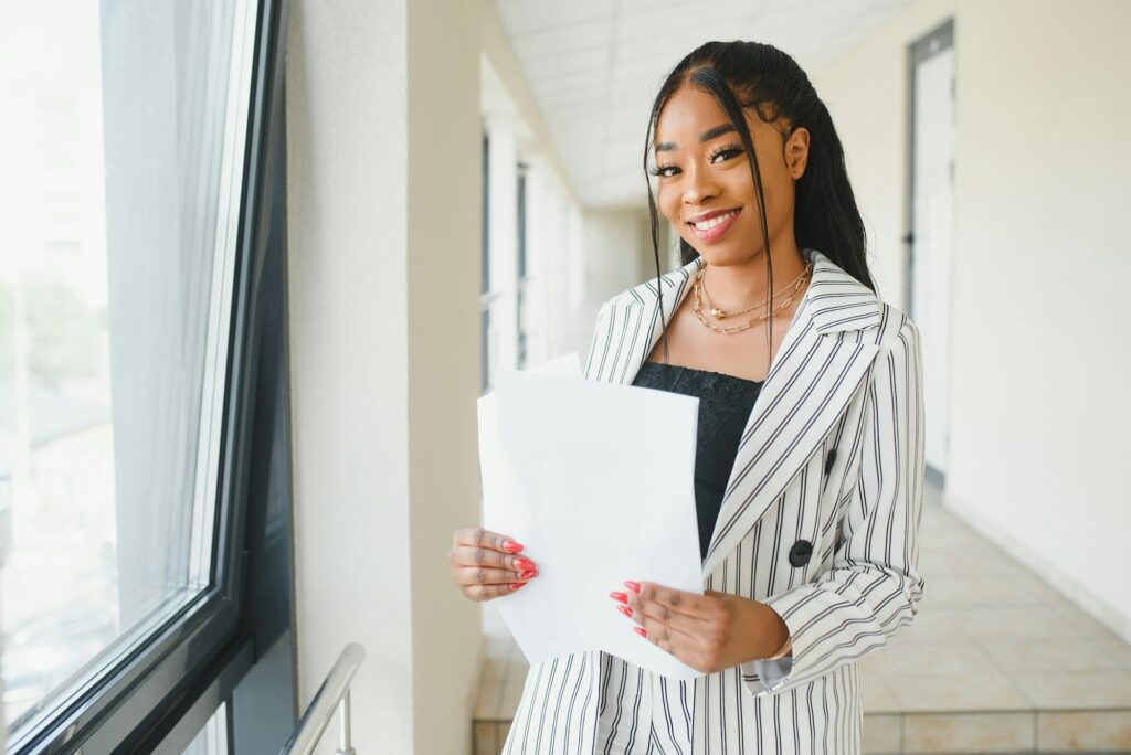 african american business woman standing, office hall with documents